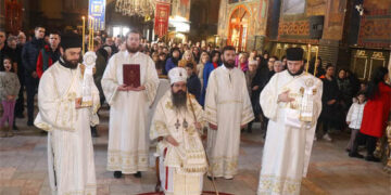 Lomljenje božićne česnice u porti Saborne crkve Svetih apostola Petra i Pavla